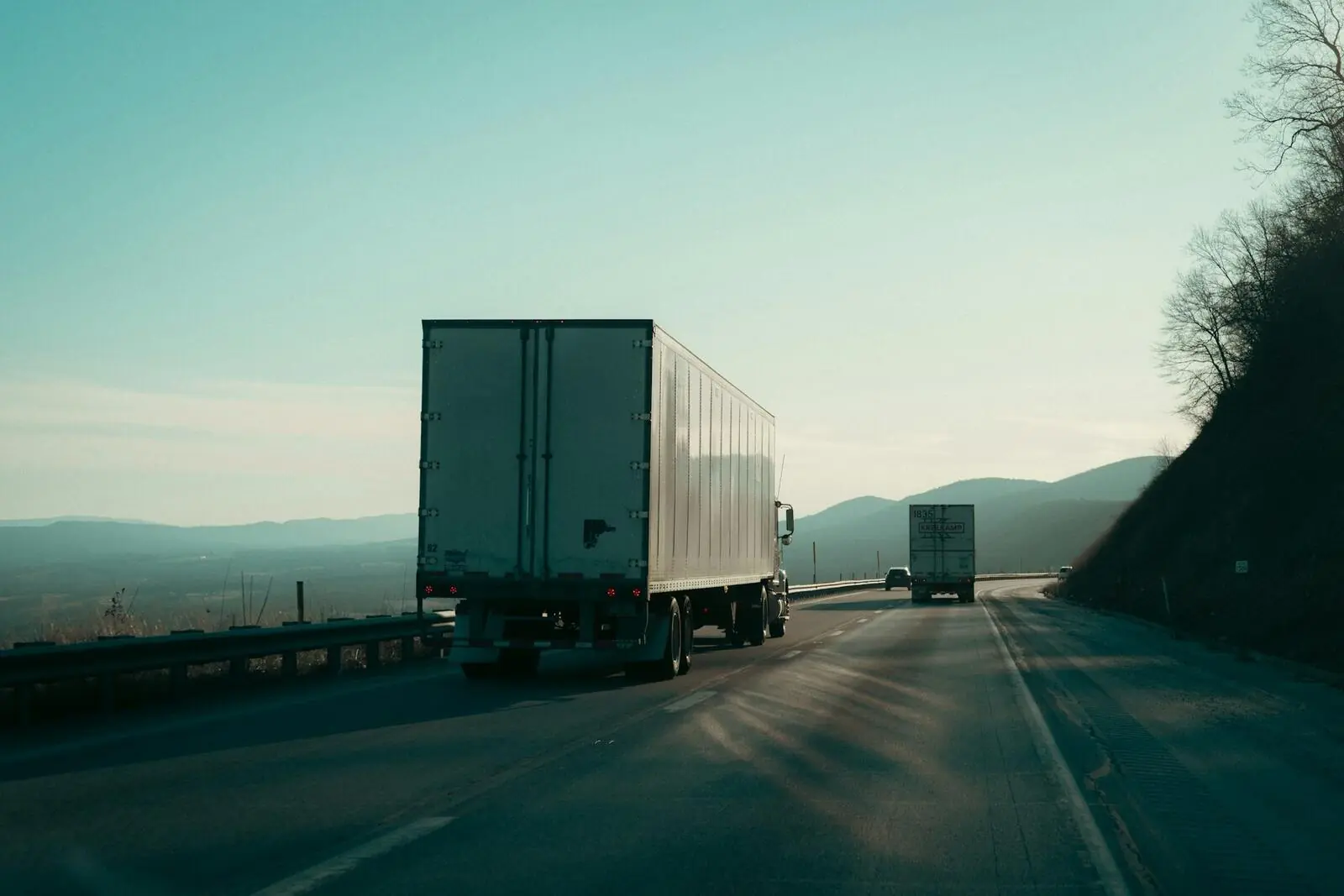 Two tractor-trailers travelling a highway